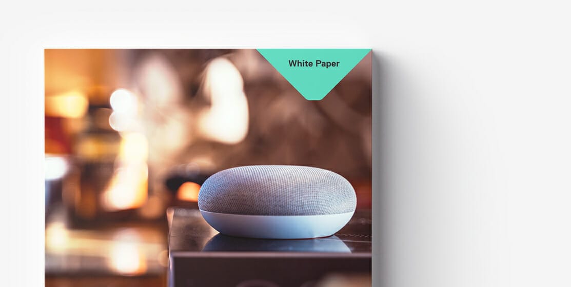 A smart speaker sits on a table. The corner of the image features a label that reads "White Paper," hinting at valuable insights for B2B procurement. The background is blurred.