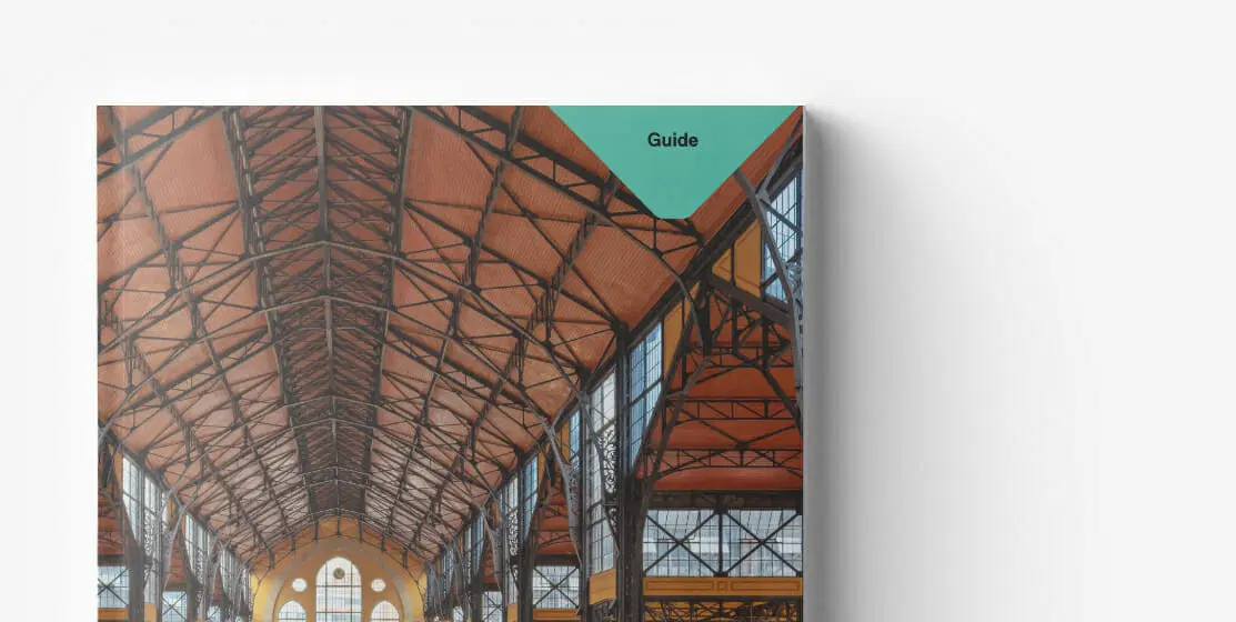 Cover of a guidebook displaying an interior view of a large, industrial-style building with a high, exposed metal roof and large windows, reminiscent of the functional elegance often highlighted in whitepapers.