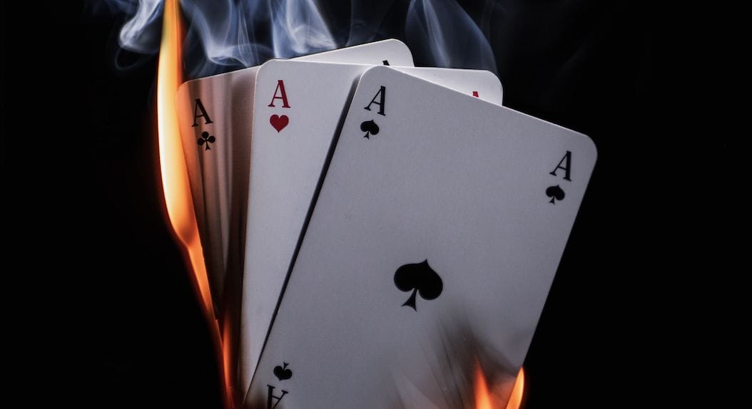 Four Ace playing cards with different suits on fire against a black background, perfect for adding a touch of magic to your e-commerce storefront.