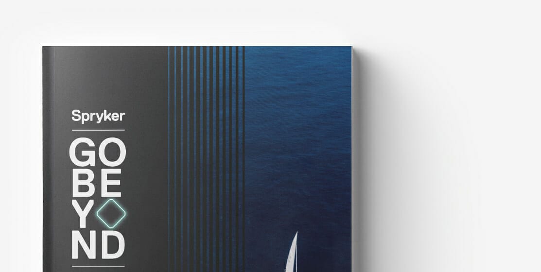 Close-up of a book titled "Spryker GO BEYOND," with a blue and black cover design featuring thin, vertical lines and a partially visible white sailboat on a blue ocean, perfect for those interested in ecommerce and international expansion.