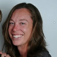 A woman with long brown hair smiles at the camera against a plain background, embodying the fresh spirit of our updated Career Page.