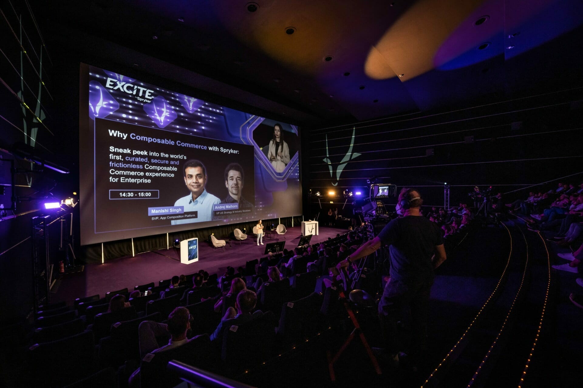 A speaker presents onstage to an audience in a large, dark auditorium at an eTail event. The screen behind displays a presentation titled "Why Composable Commerce with Spryker.