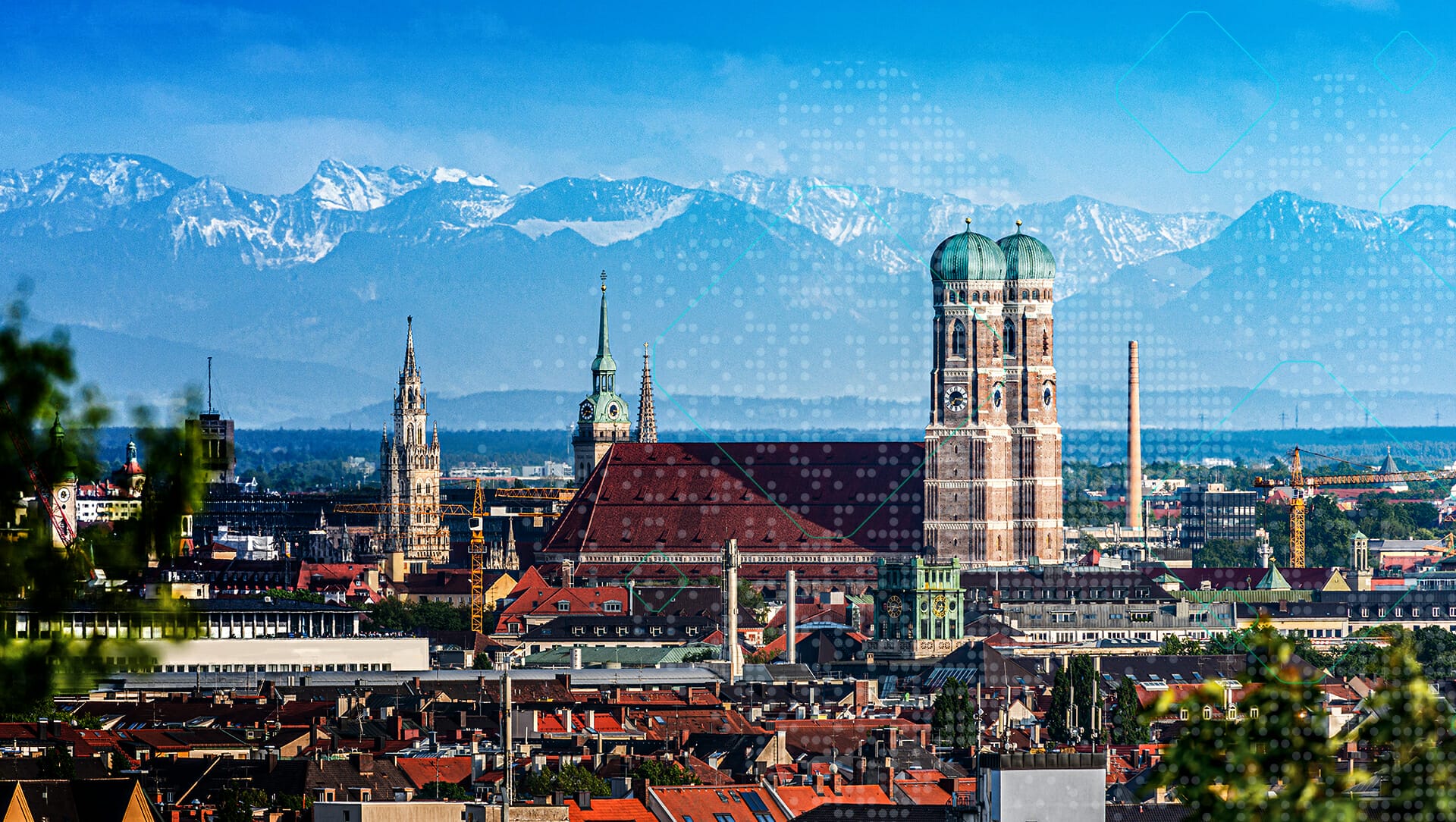 A panoramic view of a city with prominent cathedral towers and the Alps in the background on a clear day, capturing the essence of b2b-wiesn.