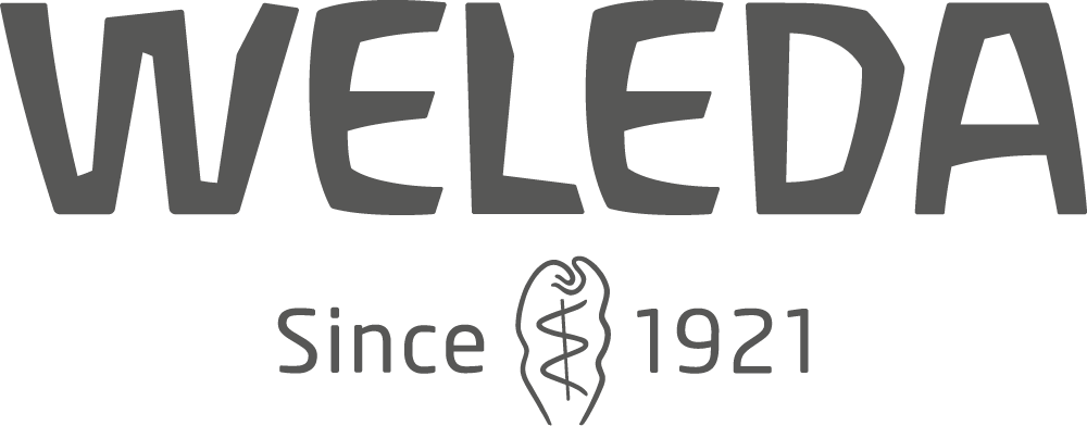 Logo of Weleda with text "Since 1921" beneath it, featuring a stylized medical symbol, showcased proudly at Spryker EXCITE 2024.