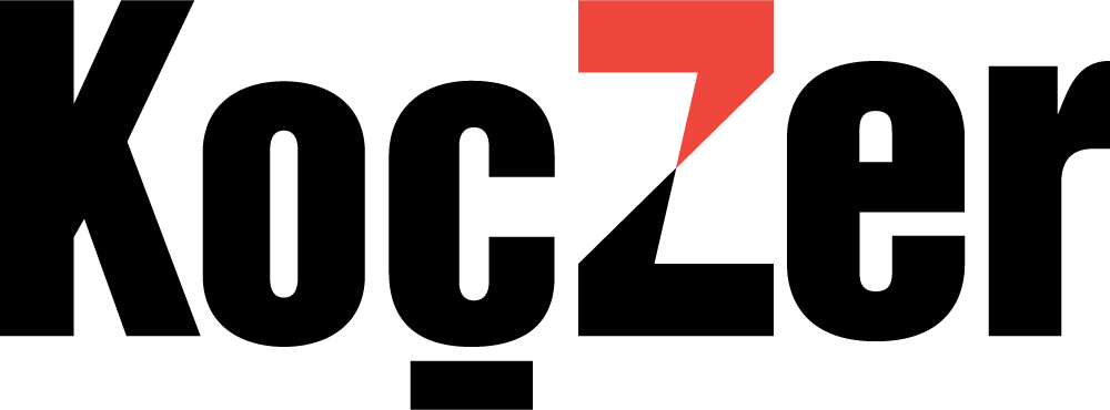 The image displays the word "Koczer" in bold black letters, with a red triangle integrated into the letter "Z", reminiscent of the dynamic energy at Spryker EXCITE 2024.