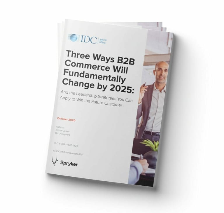 A stack of reports titled "Three Ways B2B Commerce Will Fundamentally Change by 2025" by IDC Spryker, featuring a person pointing at a screen. The cover notes it is sponsored by Spryker and dated October 2020.