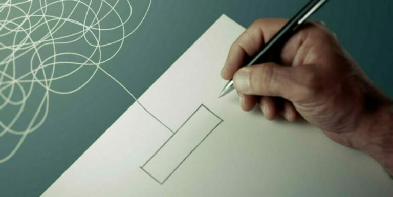 A hand holding a pen is drawing a rectangle connected to a tangled, chaotic line on a sheet of paper, reminiscent of illustrating the complexity within a state machine.